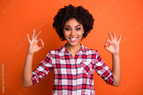 Portrait of lovely cheerful youngster teen have choice decision excellent promo feedback dressed checked shirt modern clothes isolated orange background