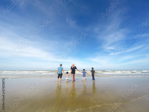 rear view of family with three children standing over beautiful blue sky. Concept of family, happiness, parenting and relationship