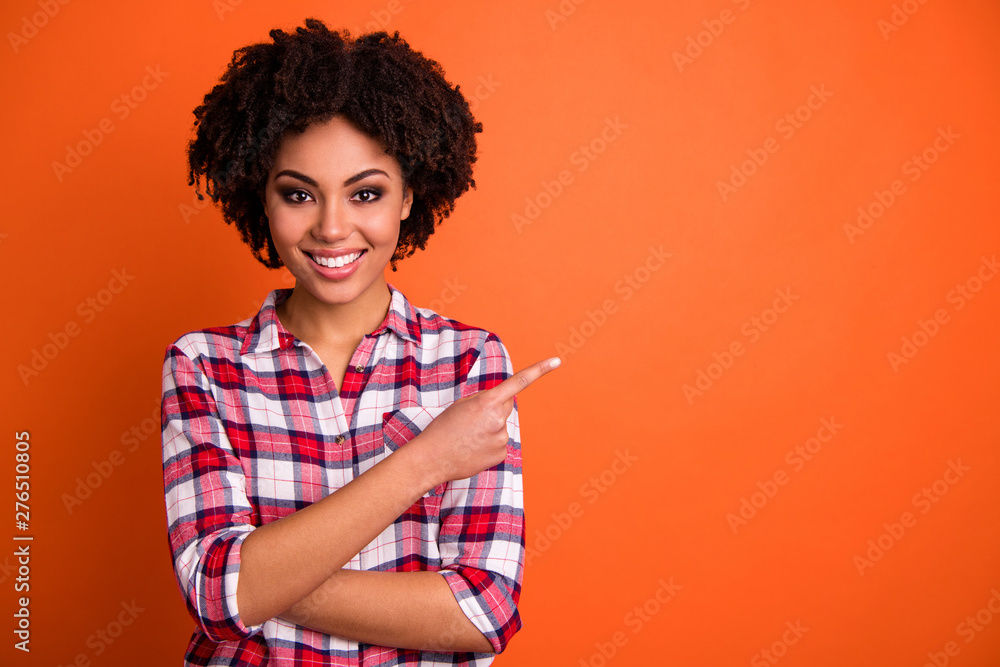 Close-up portrait of her she nice attractive cheerful cheery confident wavy-haired lady wearing checked shirt pointing aside tips feedback advert isolated on bright vivid shine orange background - obrazy, fototapety, plakaty 
