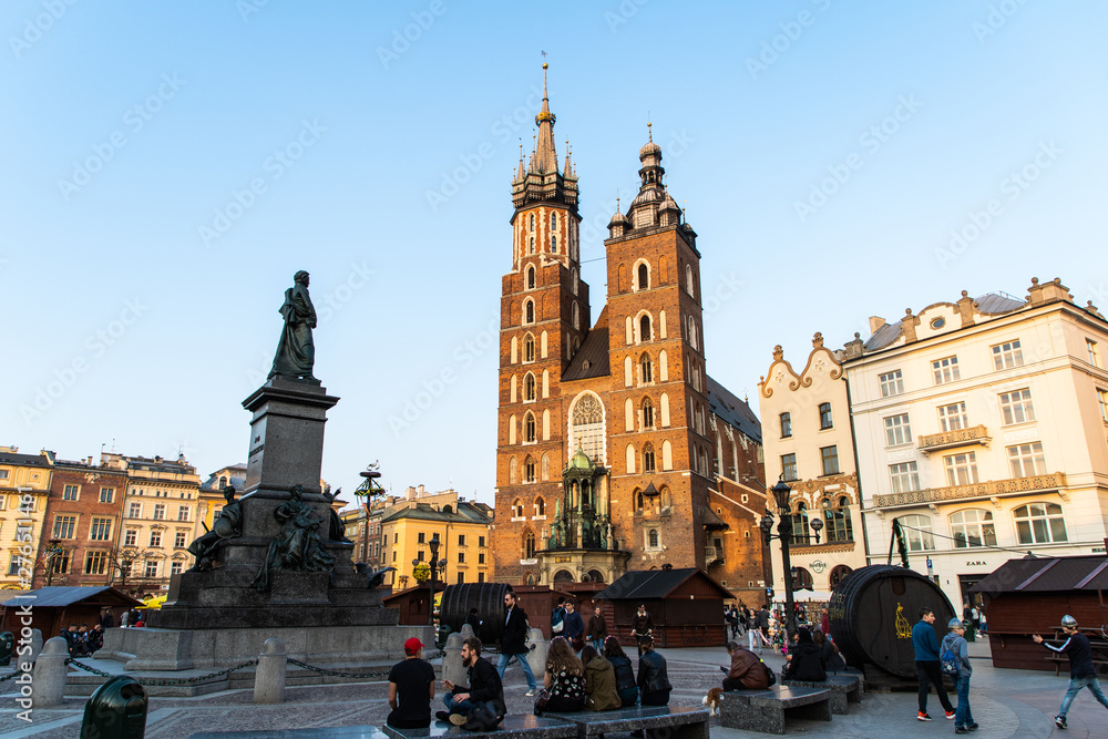 Obraz Krakow, Poland - April, 2019: Church of St. Mary and the Cloth Hall on the main market square in Krakow