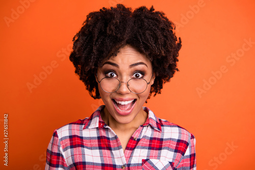 Close-up portrait of her she nice attractive cheerful cheery overjoyed optimistic wavy-haired lady nerd wearing checked shirt cool great news isolated on bright vivid shine orange background