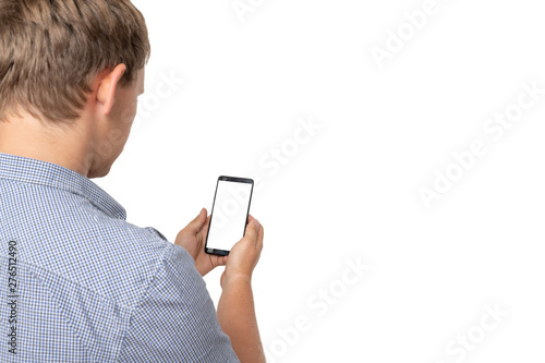 Back view of pointing young men talking on cell phone. Young guy gesture. Rear view people collection. Isolated over white background. A guy in a gray sweater works on your smartphone.