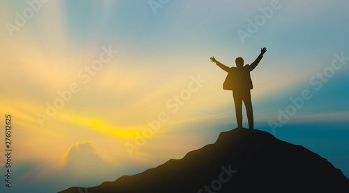 silhouette of man on mountain top over sky and sun light background business  success  leadership  achievement and people concept
