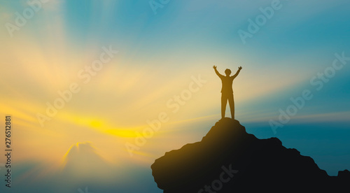 silhouette of man on mountain top over sky and sun light background,business, success, leadership, achievement and people concept