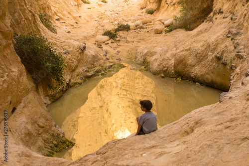 child near pond in the desert
