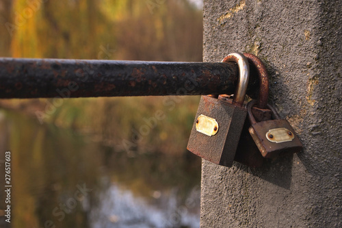 Rusty padlocks hung on the bridge during an autumn afternoon photo