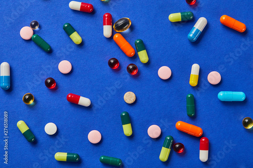 top view of different medical pills on blue background photo