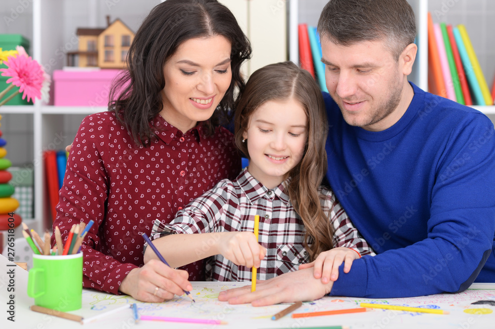 Portrait of parents and daughter doing homework Portrait of parents and daughter doing homework