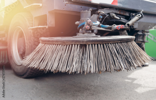 Close-up sweeper machine cleaning. Concept clean streets from debris photo