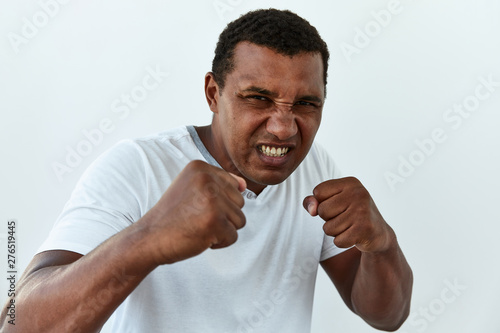 Furious, Frustrated and stress emotion. Portrait of African American man defend with hime fists against white background