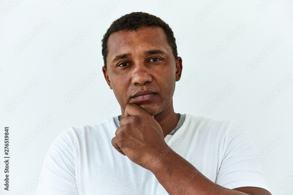 Thoughtful, thinking emotion concept. African American man touch him chin and think about something,portrait on white backgound. Thoughtful, thinking emotion concept. African American man touch him chin and think about something,portrait on white backgound.
