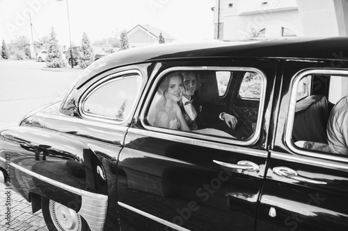 Fototapeta Naklejka Na Ścianę i Meble -  Happy bridesmaids riding in a car