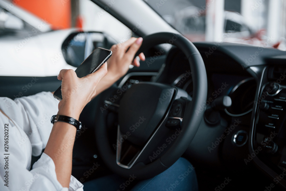 Close up view of woman's hands in the beautiful modern black colored car Close up view of woman's hands in the beautiful modern black colored car