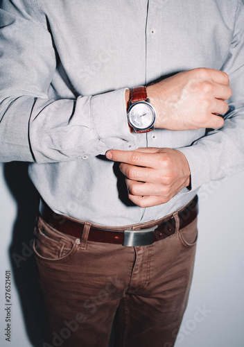 closeup fashion image of luxury watch on wrist of man.body detail of a business man.Man's hand in a checkered with cufflinks in jacket pocket closeup. Tonal correction