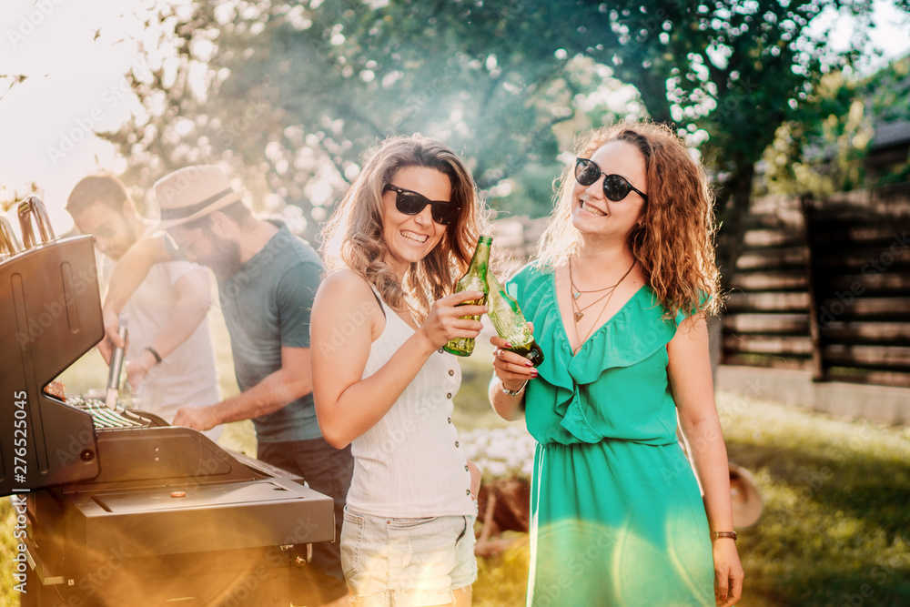 Millennials having a barbecue party, portrait of girls smiling and laughing