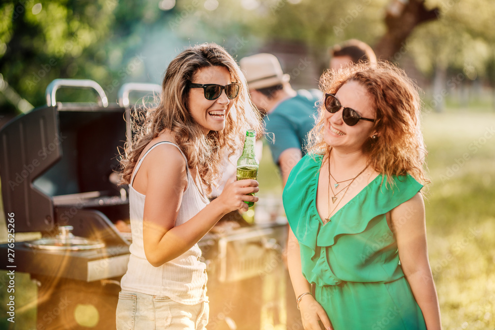 Close up portrait of girls drinking and laughing at backyard barbecue party Close up portrait of girls drinking and laughing at backyard barbecue party