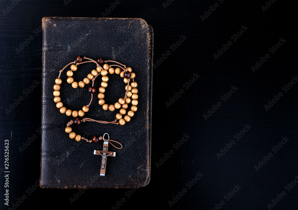 Obraz premium Rosary beads and prayer book on dark background.