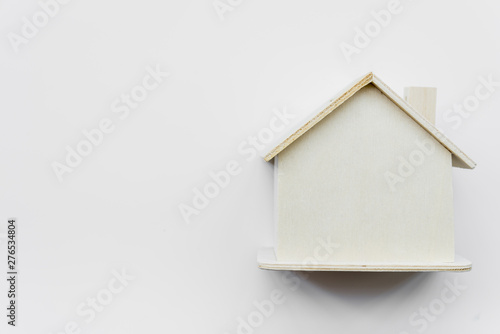 Simple miniature wooden house against white background