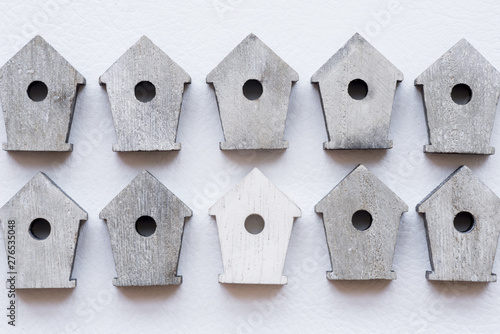 Row of wooden bird houses on white textured backdrop