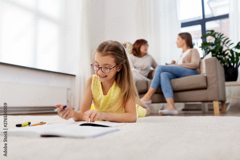education, school and learning concept - happy student girl lying on floor and writing to notebook at home education, school and learning concept - happy student girl lying on floor and writing to notebook at home