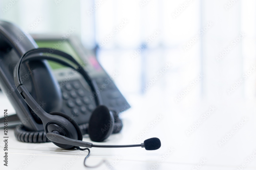 close up soft focus on headset with telephone devices at office desk for customer service support concept close up soft focus on headset with telephone devices at office desk for customer service support concept