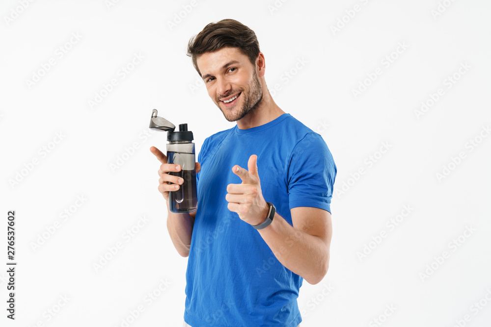 Photo closeup of cheerful man in casual t-shirt pointing finger at camera and holding water bottle Photo closeup of cheerful man in casual t-shirt pointing finger at camera and holding water bottle