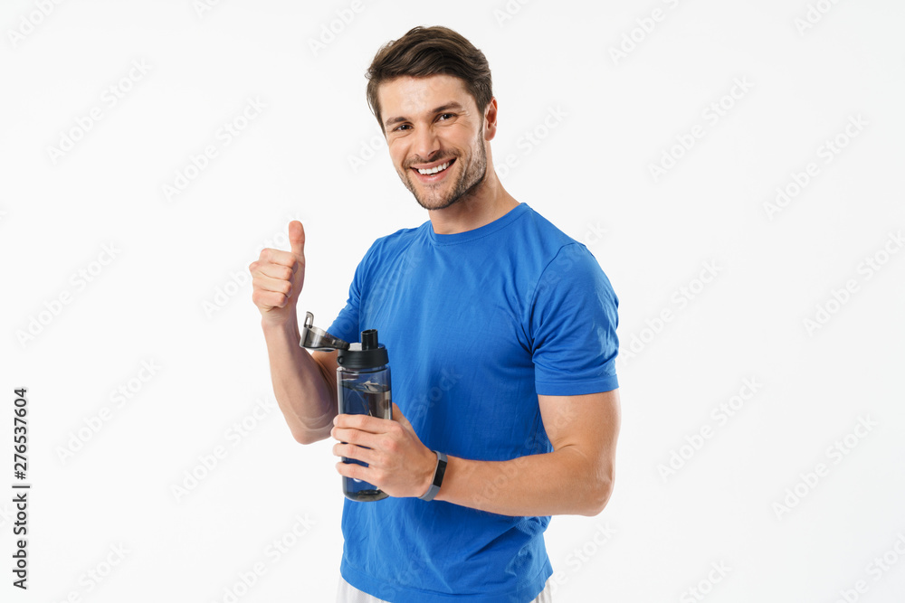 Photo closeup of good-looking man in casual t-shirt showing thumb up and holding water bottle Photo closeup of good-looking man in casual t-shirt showing thumb up and holding water bottle