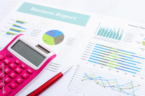 Pink calculator and red pen with business document report backgrounds