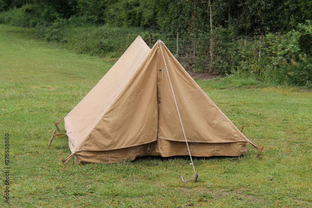 An Old Brown Canvas Camping Tent with Wooden Pegs.