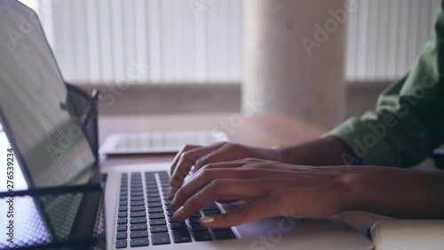 Businesswoman typing on laptop after writing on her personal organizer