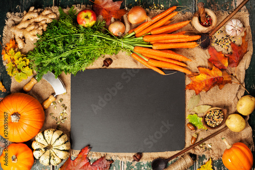Healthy food cooking background. Fresh garden carrots, pumpkins, onions, apples and spices on rustic background