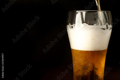 pour beer in a beer glass, tasty fresh beer in a beer grocery glass