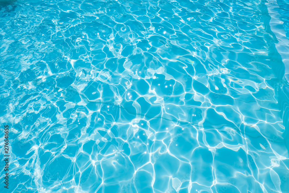 Obraz premium Abstract of blue water surface in swimming pool, Ripple wave in pool with sun reflections
