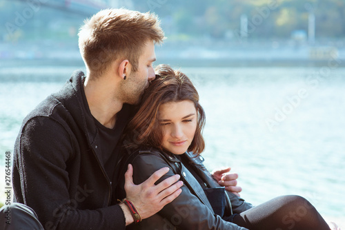 beautiful amazing funny cheerful young couple (man and woman) hugging outdoor by the river on bridge background. Girlfriend and boyfriend. Family, love and friendship concept © k8most