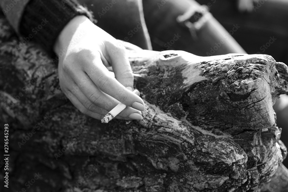 stressful young woman hand with cigarette by the tree stressful young woman hand with cigarette by the tree