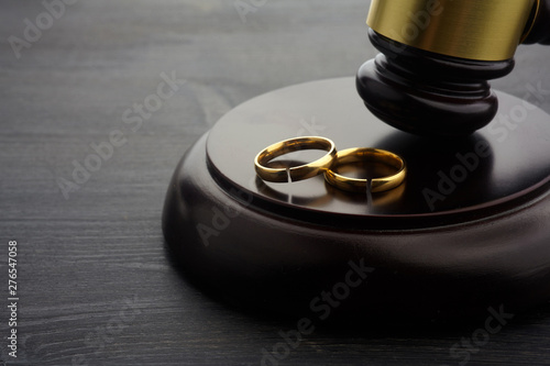 Two broken rings and hammer of a judge. Divorce concept