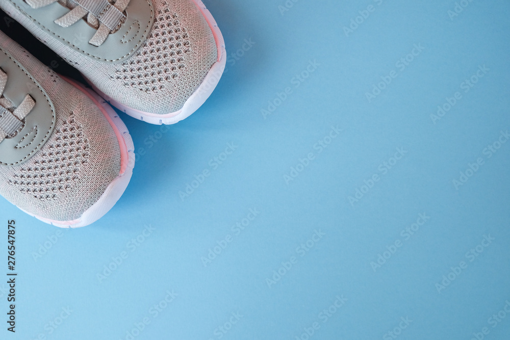 Sport, healthy lifestyle concept. New gray sneakers on pastel blue background. Copy space. Flat lay - obrazy, fototapety, plakaty 