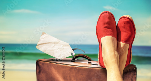 Fototapeta Naklejka Na Ścianę i Meble -  Beine mit roten Stoffschuhen vor Strand und Meer