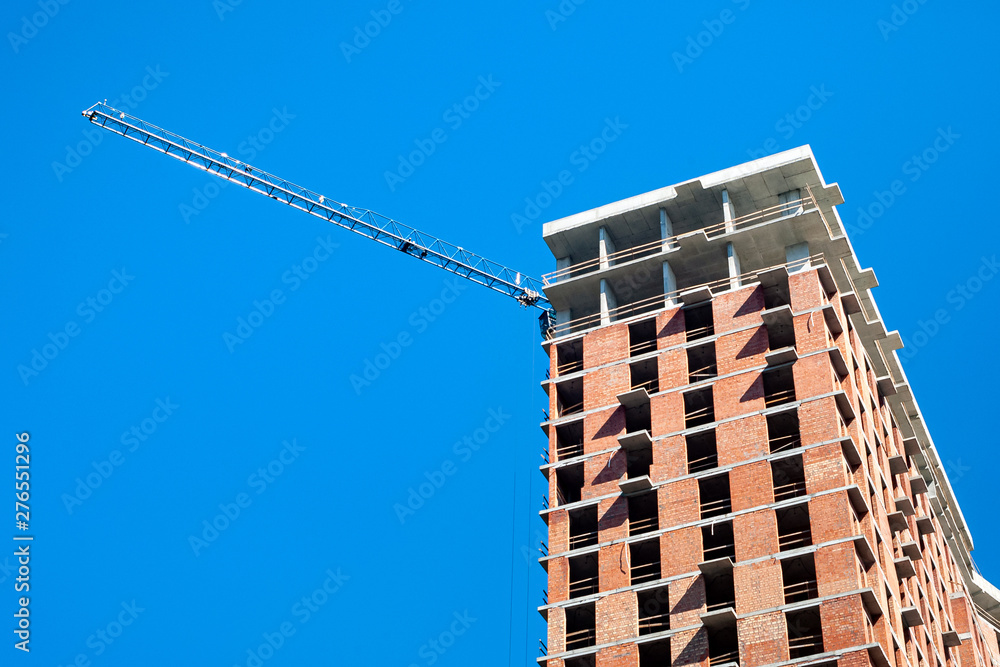 Construction site with crane against the blue sky.