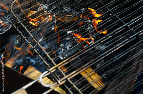 The grid of a grill gets warm on coals