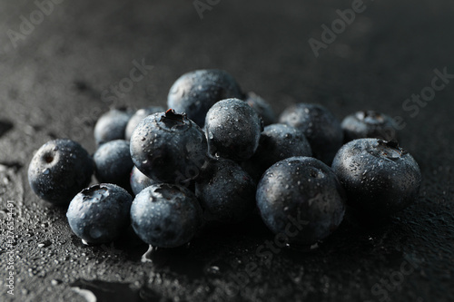 Blueberries on black cement background with drops, space for text