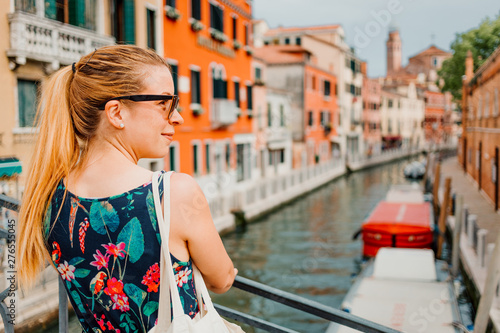 Young woman standing on the bridge in Venice, Italy enjoying the view