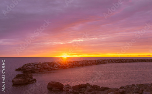 Beautiful summer sunrise by the sea width colorful cloudy sky.