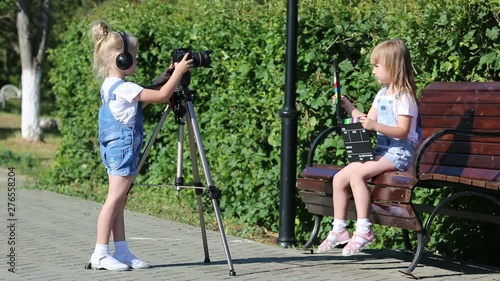 Girls of 4-5 years old are shooting video on a photo machine, playing television workers. photo