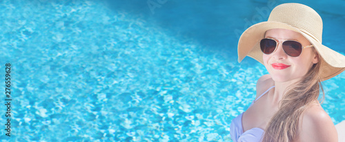 Summertime in pool. Young woman with floppy hat and at pool. © PhotoGranary