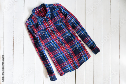 Clothes concept. Blue and red checkered shirt on wooden background. Top view