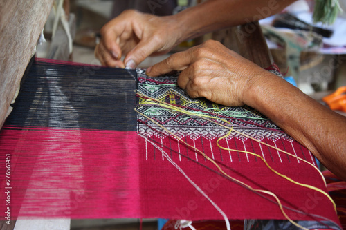 Woman hand weaving traditional Thai cloth at Mae Chaem, Chiangmai, Thailand. photo