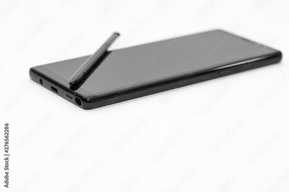 Modern, glass smartphone on white background, focus on the stylus, copy space. Modern, glass smartphone on white background, focus on the stylus, copy space.