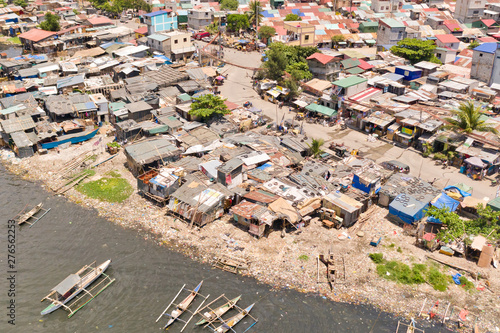 Slums in Manila, a top view. Houses of poor people and boats in poor areas. Sea pollution by household waste. Plastic trash on the beach.
