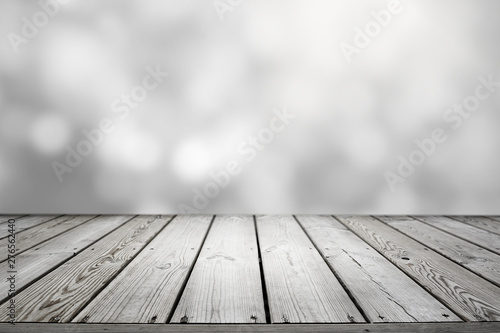 Blurred abstract white grey bokeh background and wooden table.